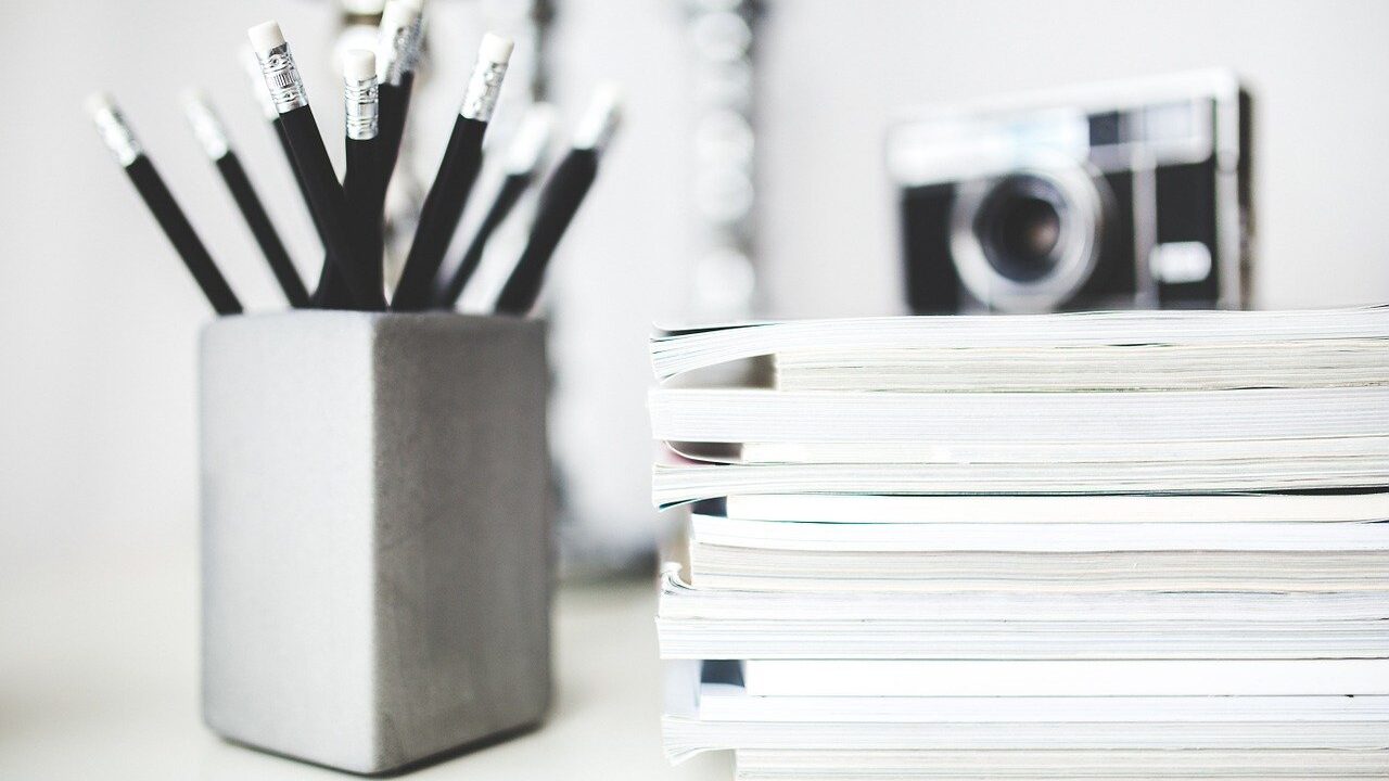 Boite à crayons avec des magazines et un appareil photo